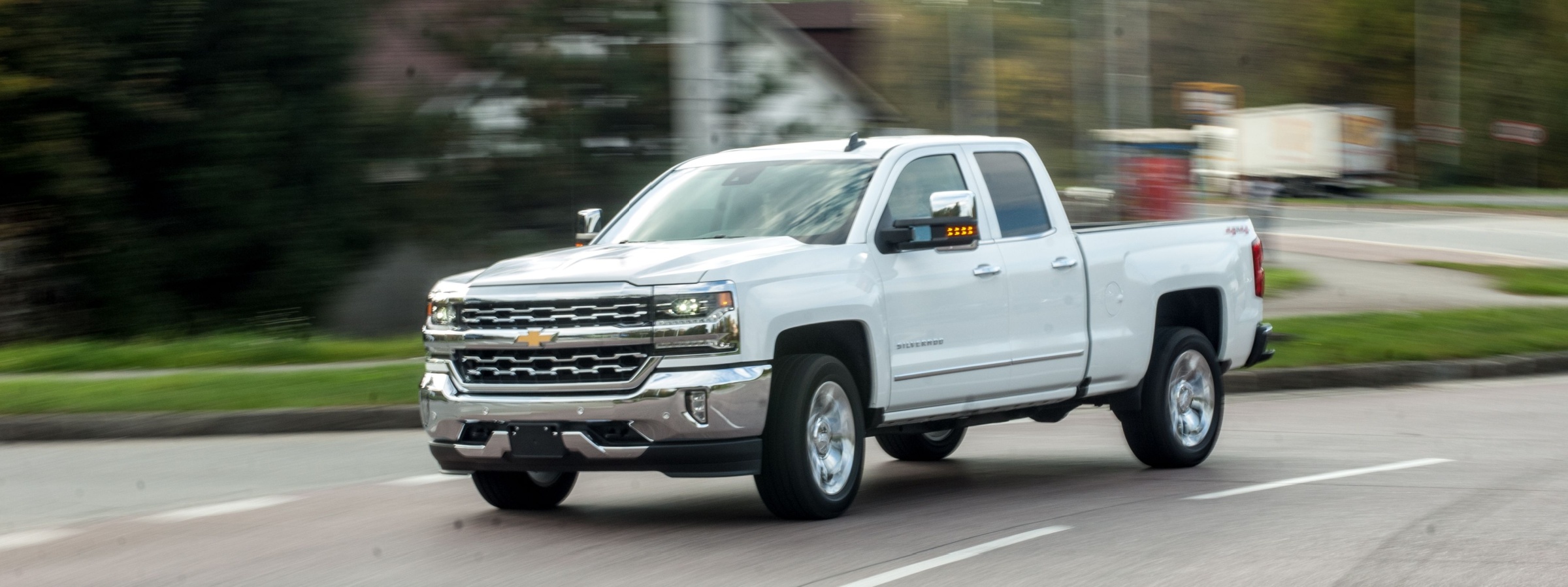 White Chevrolet Silverado-1500 driving down a road