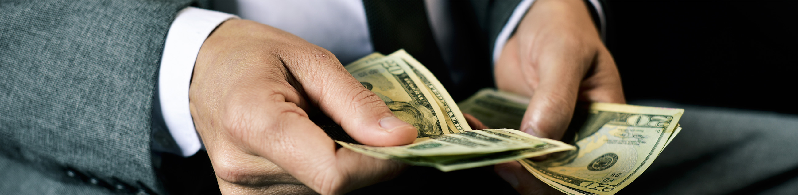 Man in suit holding money in hand