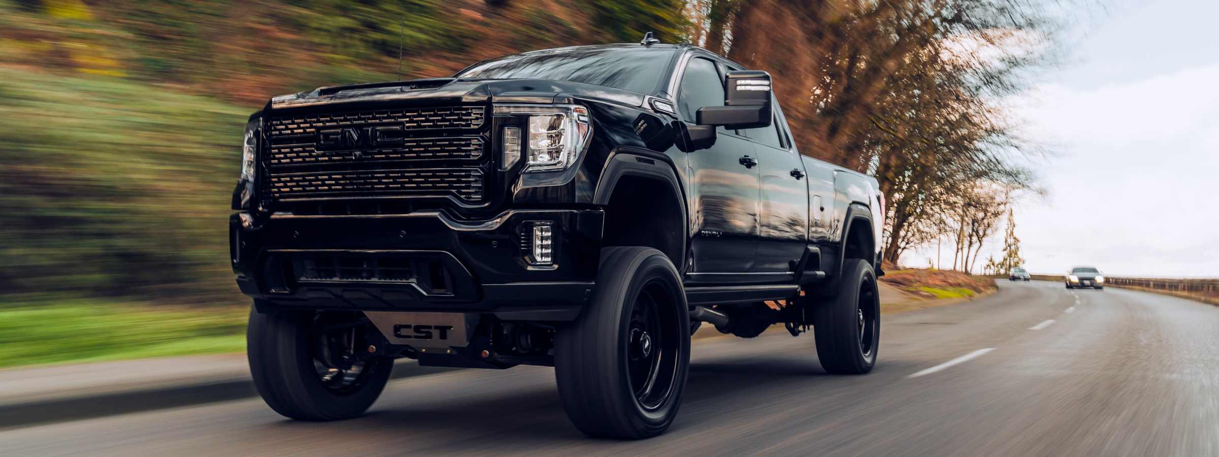 A GMC truck driving down scenic path