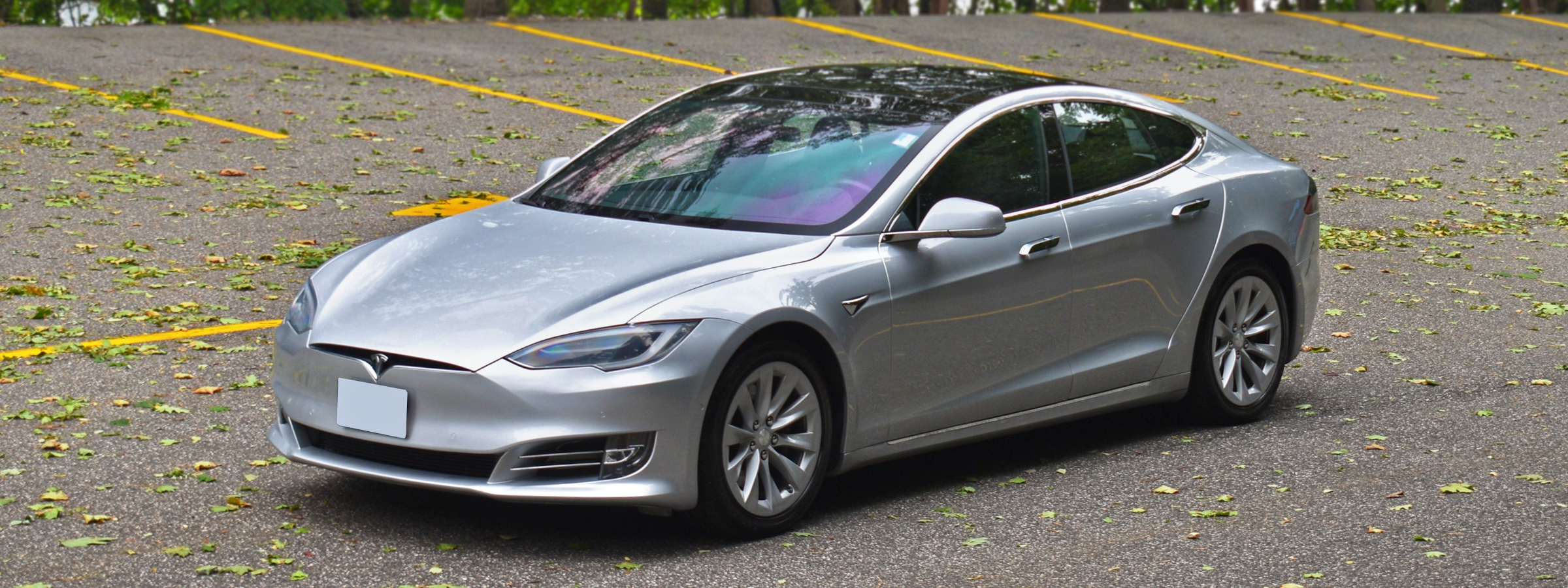 A silver Tesla Model S in a parking lot