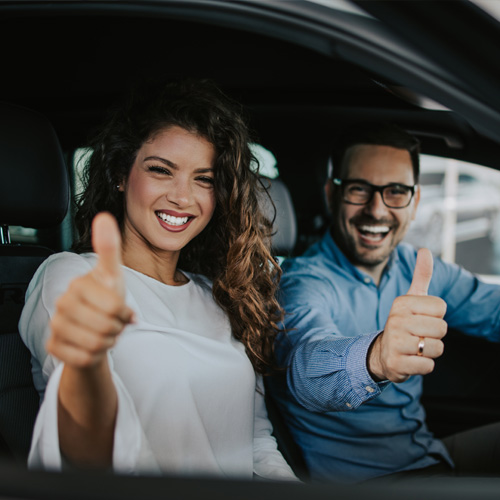 Smiling man putting on a seatbelt.