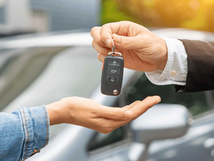 Close up of a person holding keys over a customers hand