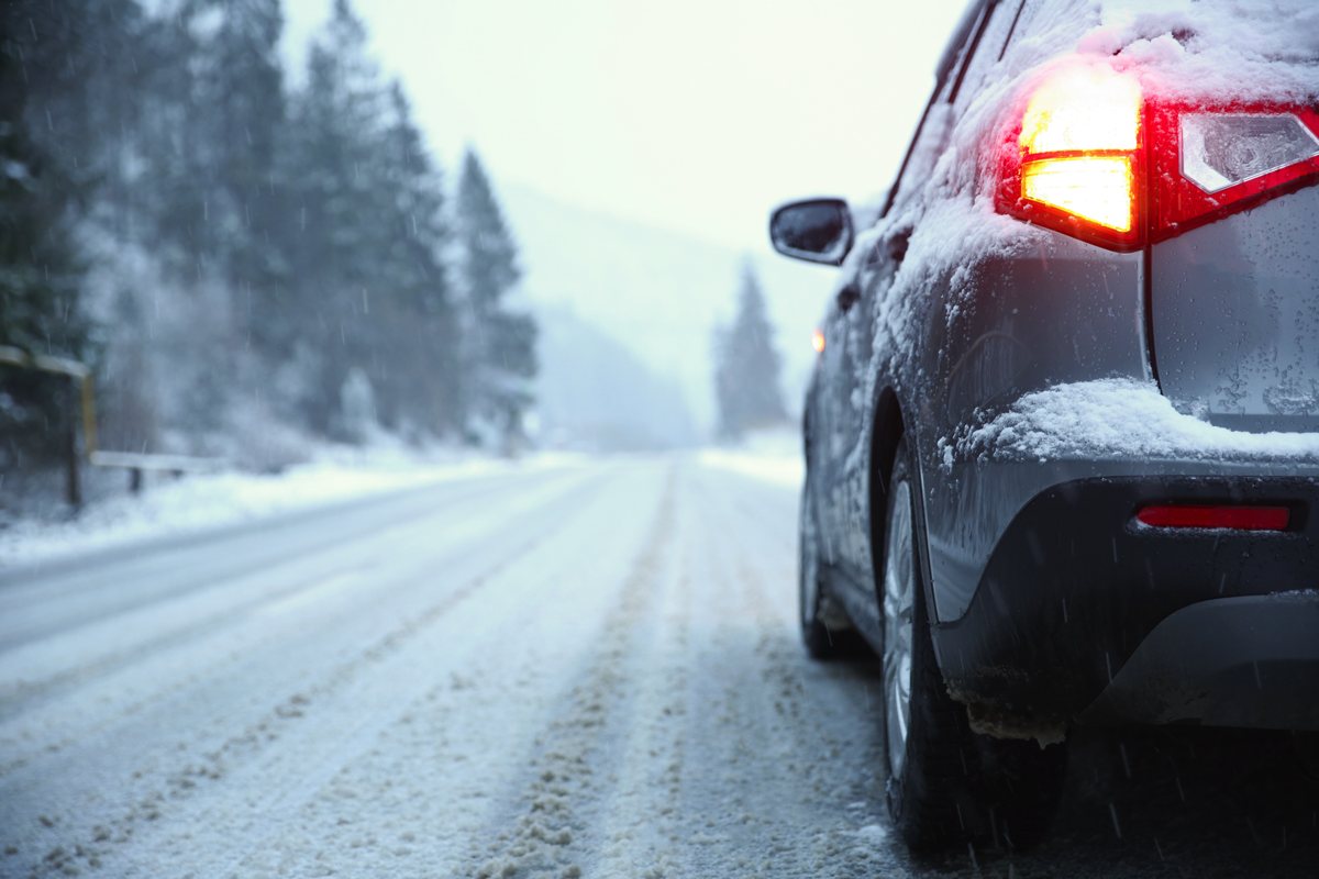 A BMW driving on a snowy mountain road.