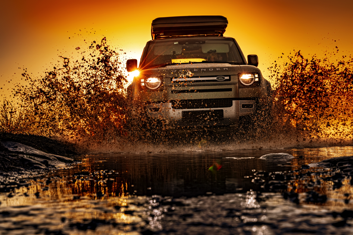 A Land Rover driving through a muddy field