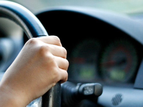 A hand gripping a steering wheel