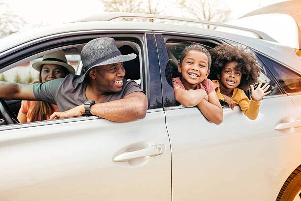 Happy family driving away in their vehicle after being approved for a car loan despite having a bad credit with Byron center Motors in Byron Center MI