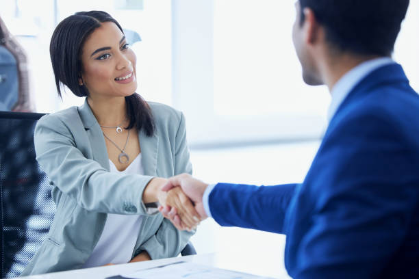 customers shaking hands with employee accepting new credit acceptance auto loan regardless of their bad credit at Used car dealership Byron center Motors, Byron Center MI