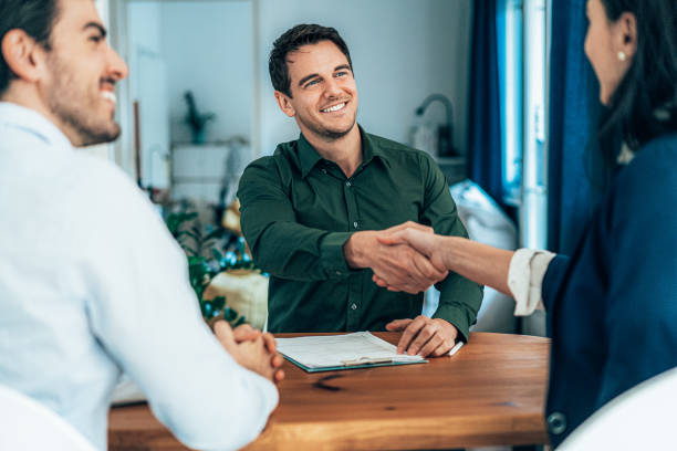 customers shaking hands with employee accepting new credit acceptance auto loan regardless of their bad credit at Used car dealership Byron center Motors, Byron Center MI