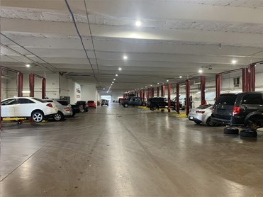 Indoor Service Bays with gray hatchback, black sedan, and red van