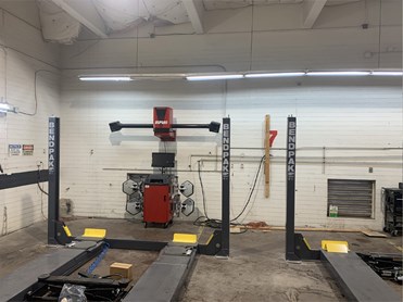 Indoor Service Bays with gray hatchback, black sedan, and red van